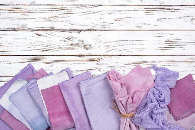 A display of various cotton fabrics in different colors and patterns.  The fabrics range from lightweight voile to slightly heavier chambray. They are neatly folded and arranged on a table.