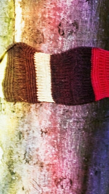 A collage of various knitwear pieces in a range of bold and muted colors, including oversized sweaters, sweater vests, and scarves, demonstrating the color trends for the season.