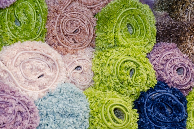 A close-up shot of various fabric swatches showcasing modern floral prints. The fabrics feature a mix of bold, geometric floral designs and abstract floral patterns, using a vibrant color palette that includes neon pinks, electric blues, and deep greens. The textures of the fabrics are visible, highlighting their quality and the intricacy of the floral designs.