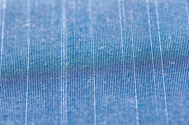 Close-up shot of denim fabric made from recycled materials. The texture is visible, showing the reclaimed fibers and unique weave patterns. The color is a natural indigo shade, and the background is blurred to focus on the fabric's details.