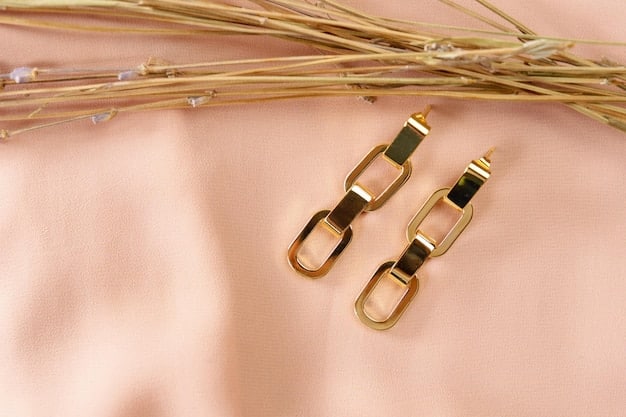 A flat lay of stylish, minimalist gold jewelry including a dainty necklace with a small pendant and thin hoop earrings, alongside a stack of simple rings, emphasizing understated elegance.