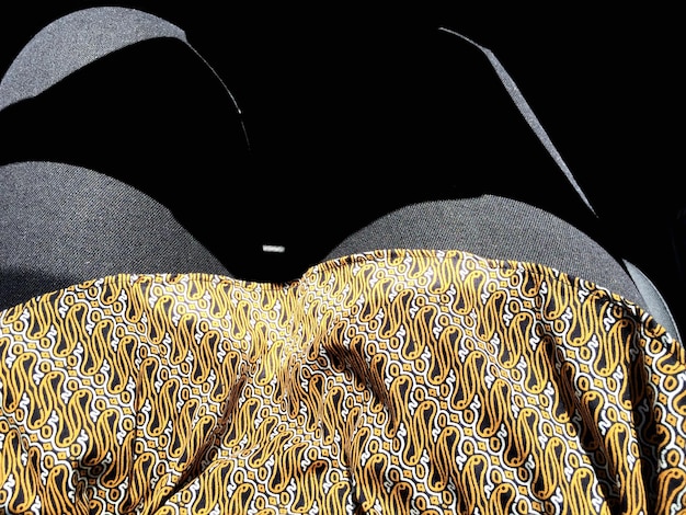 A close-up shot of a silk midi skirt featuring a subtle, abstract zebra print, paired with a simple black knit top and delicate gold jewelry.