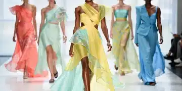 Models on runway showcasing vibrant Spring 2026 fashion trends with flowing fabrics and innovative silhouettes.